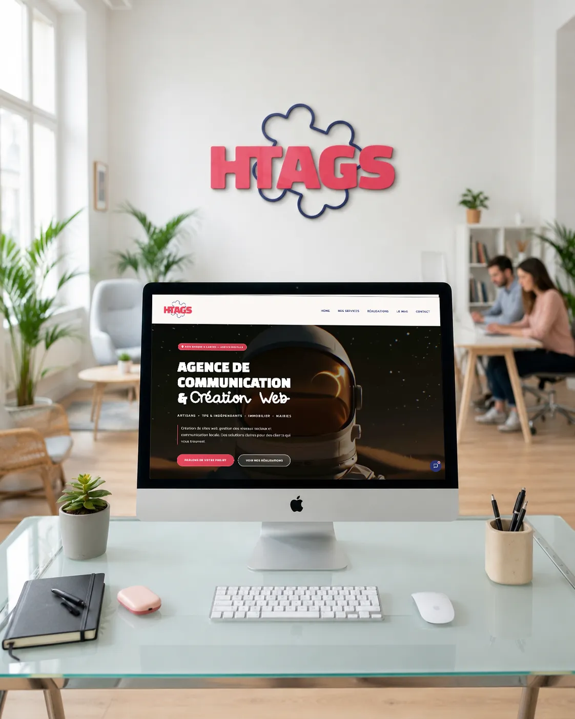 Le site HTAGS affiché sur un iMac, dans les bureaux de l'agence
