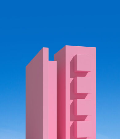 Structure architecturale rose en forme de building stylisé, photographiée sous un ciel bleu clair.